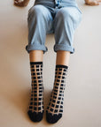 chaussettes transparentes à carreaux noirs jean bleu vue de haut les genoux relevés